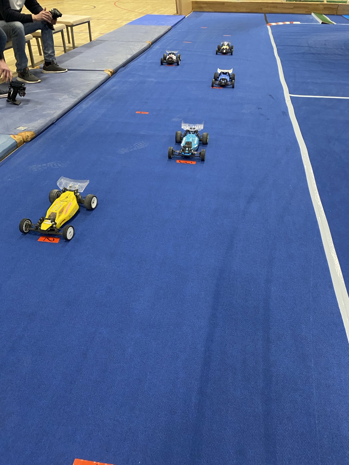 Mehrere Buggys auf der blauen Teppichrennstrecke
